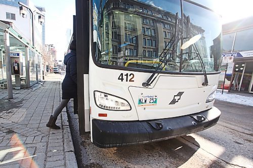 MIKE DEAL / WINNIPEG FREE PRESS
People get on a transit bus at the Graham and Vaughan bus stop in downtown Winnipeg Wednesday morning. 
210303 - Wednesday, March 3, 2021.