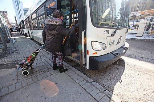 MIKE DEAL / WINNIPEG FREE PRESS
People get on a transit bus at the Graham and Vaughan bus stop in downtown Winnipeg Wednesday morning. 
210303 - Wednesday, March 3, 2021.