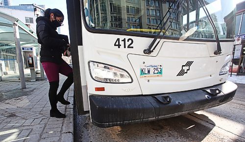 MIKE DEAL / WINNIPEG FREE PRESS
People get on a transit bus at the Graham and Vaughan bus stop in downtown Winnipeg Wednesday morning. 
210303 - Wednesday, March 3, 2021.