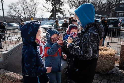 Daniel Crump / Winnipeg Free Press. Parker Hedlin (right) hands out chocolate sprinkle ice cream cones to his siblings and cousins at the Bridge Drive-In. March 6, 2021.