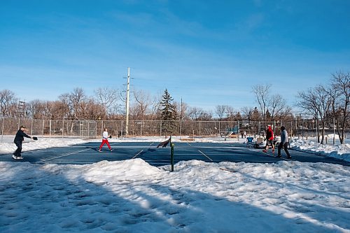 Daniel Crump / Winnipeg Free Press. Three generations of the Kliewer family enjoy the warm spring weather as they play pickle ball on a tennis court that has been cleared of snow. March 6, 2021.