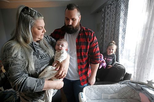 JOHN WOODS / WINNIPEG FREE PRESS
Hayleigh McMullen, 2, peeks around as her parents Ashleigh and Rob hold her brother Lachlan, 4 months, in their home in Winnipeg Thursday, March 11, 2021. McMullen, a mother of two, including a 4-month old son, Lachlan, who has a severe heart condition, is calling the COVID-19 rules that doctor's appointments only have one person - even if the other person lives in the same residence or is a doula/caregiver - "traumatic.

Reporter: Abas