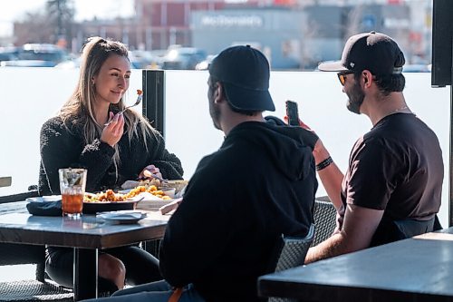 Daniel Crump / Winnipeg Free Press. Carly Taggart (left) and friends spend time together on the patio at Fionns on Grant Avenue Saturday afternoon. March 13, 2021.