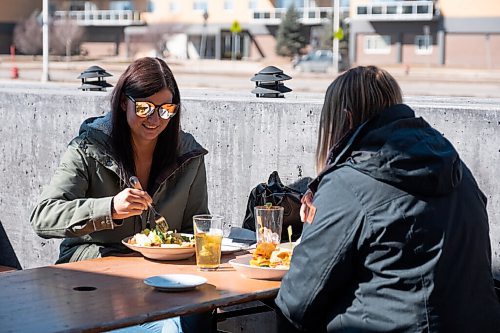 Daniel Crump / Winnipeg Free Press. Dallas Kaeding (left) and Alli Breddam have a meal together on the patio at Fionns on Grant Avenue. March 13, 2021.