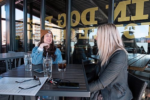 Daniel Crump / Winnipeg Free Press. Kathryn Huebner (left) and Jen Li sit on the patio at Fionns on Grant Avenue and chat as they wait for their food to arrive. March 13, 2021.