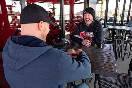 Daniel Crump / Winnipeg Free Press. Matt Abra (right) and Chris Leblonde chat and enjoy some drinks as they hangout on the patio at Fionns on Saturday afternoon. March 13, 2021.