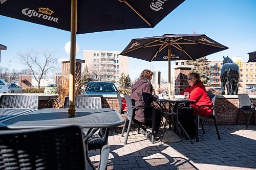 Daniel Crump / Winnipeg Free Press. Linda Smith (left) and Cathie Turner spend time together on the patio at the Pony Corral on Grant Avenue on Saturday afternoon. March 13, 2021.
