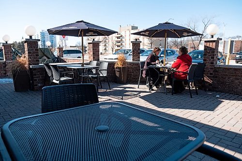 Daniel Crump / Winnipeg Free Press. Linda Smith (left) and Cathie Turner spend time together on the patio at the Pony Corral on Grant Avenue on Saturday afternoon. March 13, 2021.