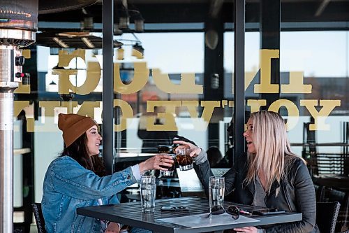 Daniel Crump / Winnipeg Free Press. Kathryn Huebner (left) and Jen Li sit on the patio at Fionns on Grant Avenue and chat as they wait for their food to arrive. March 13, 2021.