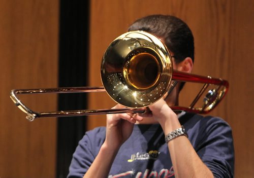 Brandon Sun 08012010 Dylan Woodcock of Minnedosa Collegiate is obscured by his trombone during rehearsal for the Westman Senior Honour Band at the Western Manitoba Centennial Auditorium on Friday morning. Both the junior and senior honour bands, made up of middle and high school students from 25 westman schools, will perform today at 3:00PM at the WMCA.  (Tim Smith/Brandon Sun)