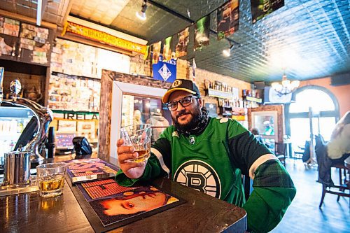 MIKE SUDOMA / WINNIPEG FREE PRESS 
Kings Head regular, Paul Deonaraine, has waited two years to wear his green Boston Bruins jersey to the pub on St Patricks Day. With easing restrictions, he is quite happy to be able to finally wear his jersey and sip a whiskey at one of his favourite pubs.
March 17, 2021