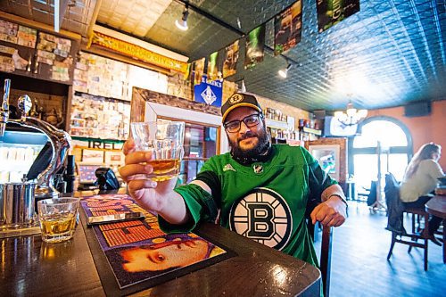 MIKE SUDOMA / WINNIPEG FREE PRESS 
Kings Head regular, Paul Deonaraine, has waited two years to wear his green Boston Bruins jersey to the pub on St Patricks Day. With easing restrictions, he is quite happy to be able to finally wear his jersey and sip a whiskey at one of his favourite pubs.
March 17, 2021
