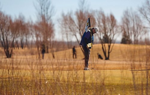 MIKE DEAL / WINNIPEG FREE PRESS
A golfer finishes his put on the 9th green at Southside Golf Course, Thursday afternoon. 
Eager golfers take to the links at Southside Golf Course (2226 Southside Road, Grande Pointe) on a blustery Thursday.
210318 - Thursday, March 18, 2021.