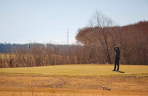 MIKE DEAL / WINNIPEG FREE PRESS
A golfer lines up a long put on the 12th green at Southside Golf Course, Thursday afternoon.
Eager golfers take to the links at Southside Golf Course (2226 Southside Road, Grande Pointe) on a blustery Thursday.
210318 - Thursday, March 18, 2021.