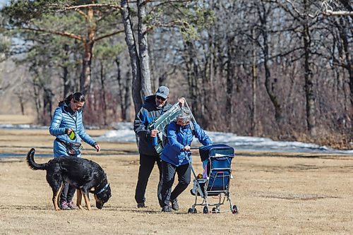 MIKE DEAL / WINNIPEG FREE PRESS
Vicki Asu with dog Dexter, Joe and Angela Gaspar walk across a very windy field at La Barriere park Friday afternoon.
210319 - Friday, March 19, 2021.