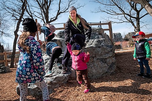 Daniel Crump / Winnipeg Free Press. Teagan Sleeva helps Rhettley (1) as they climb down from some rocks at the Assiniboine Park Zoo. Many families flocked to the zoo as the Winnipeg saw record breaking high temperatures Saturday. March 20, 2021.