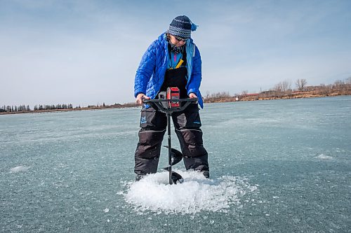 Daniel Crump / Winnipeg Free Press. Roselle Turenne drills a hole for ice fishing on a lake at Fort Whyte Alive. Despite record breaking spring weather the ice in that area of the lake is still about two and a half feet thick. March 20, 2021.