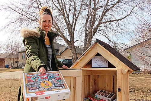 Canstar Community News Nicole Hyde stands by the puzzle library at 51 Rue Rocan in La Salle on March 15. Hyde has gone through many puzzles over the past several months and wanted a way to trade with neighbours. (GABRIELLE PICHÉ/CANSTAR COMMUNITY NEWS/HEADLINER)