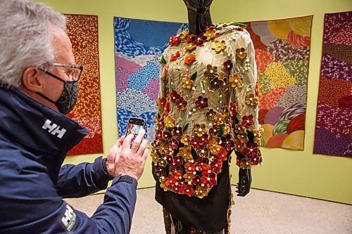 MIKE DEAL / WINNIPEG FREE PRESS
Allan Brooks, a donor of the WAG, takes a photo of a stunning piece by artist Maata Kyak called Our Flourishing Culture, 2020, made of silk, embroidery lace, dyed sealskin, beads, and pearls during a sneak peek Tuesday for donors and members of the WAG's Quamajuq in advance of the grand opening later this week.
210323 - Tuesday, March 23, 2021.