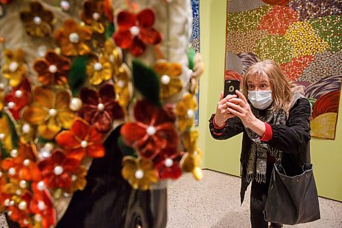 MIKE DEAL / WINNIPEG FREE PRESS
Lucie-Madeleine Delisle, artist and member of the WAG, takes a photo of a stunning piece by artist Maata Kyak called Our Flourishing Culture, 2020, made of silk, embroidery lace, dyed sealskin, beads, and pearls during a sneak peek Tuesday for donors and members of the WAG's Quamajuq in advance of the grand opening later this week.
210323 - Tuesday, March 23, 2021.