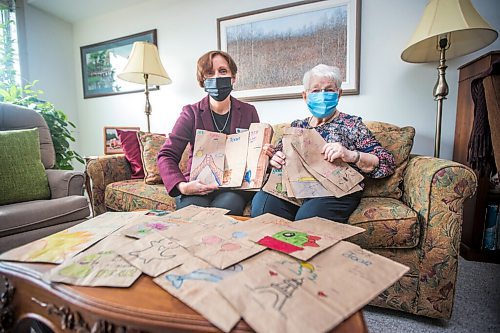 MIKAELA MACKENZIE / WINNIPEG FREE PRESS

Executive director Luise Sawatzky (left) and resident Joan Grenon pose for a photo with the decorated bags at Boulton River Heights Retirement Community complex in Winnipeg on Wednesday, March 24, 2021. Every day servers at the complex are transforming about 100 plain brown paper bags into works of art as residents take their meals in their suites during lockdown. For Doug story.

Winnipeg Free Press 2021