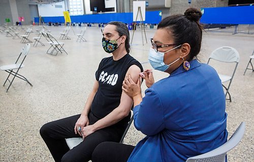 MIKE DEAL / WINNIPEG FREE PRESS
Grand Chief Arlen Dumas receives his COVID-19 immunization from Dr. Marcia Anderson, public health lead, First Nation Pandemic Response Coordination Team at the Vaccination Supercentre in the RBC Convention Centre Thursday morning.
210325 - Thursday, March 25, 2021.