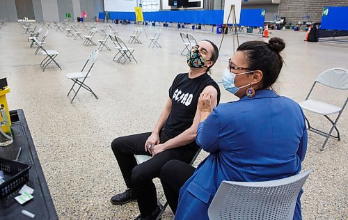 MIKE DEAL / WINNIPEG FREE PRESS
Grand Chief Arlen Dumas laughs after he received his COVID-19 immunization from Dr. Marcia Anderson, public health lead, First Nation Pandemic Response Coordination Team at the Vaccination Supercentre at the RBC Convention Centre Thursday morning.
210325 - Thursday, March 25, 2021.