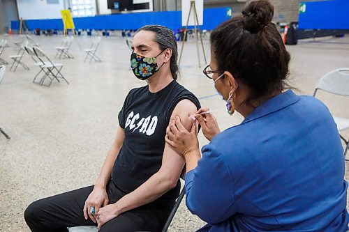 MIKE DEAL / WINNIPEG FREE PRESS
Grand Chief Arlen Dumas receives his COVID-19 immunization from Dr. Marcia Anderson, public health lead, First Nation Pandemic Response Coordination Team at the Vaccination Supercentre in the RBC Convention Centre Thursday morning.
210325 - Thursday, March 25, 2021.