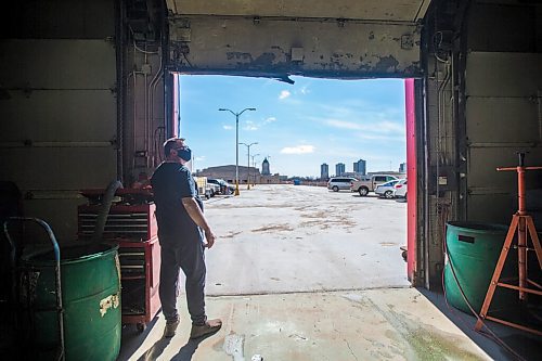 MIKAELA MACKENZIE / WINNIPEG FREE PRESS

Mike Timlick, owner of the Auto Centre on top of The Bay parking garage, opens up one of the bay doors to reveal the view in Winnipeg on Thursday, March 25, 2021.  For Ben Waldman story.

Winnipeg Free Press 2021