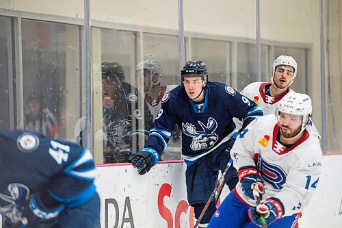 MIKE SUDOMA / WINNIPEG FREE PRESS 
Moose Defence, Leon Gawanke, moves the puck up the boards to Centre, Cole Maier as the Manitoba Moose face off against the Laval Rocket Thursday evening at the Bell MTS Iceplex 
March 21, 2021