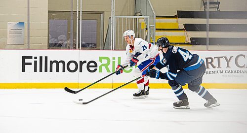 MIKE SUDOMA / WINNIPEG FREE PRESS 
Laval Rocket Right Wing, Jesse Ylonen keeps the puck away from Manitoba Moose Defence, Declan Chisholm, as he works it up the boards during Thursday evenings game at Bell MTS Iceplex 
March 21, 2021