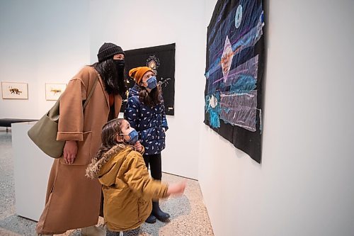 Daniel Crump / Winnipeg Free Press. Nina and Milan Moore look at a textile art piece with their mother Anne-Marie Moore at Qaumajuq, the newly opened Inuit art centre, at the Winnipeg Art Gallery. March 27, 2021.