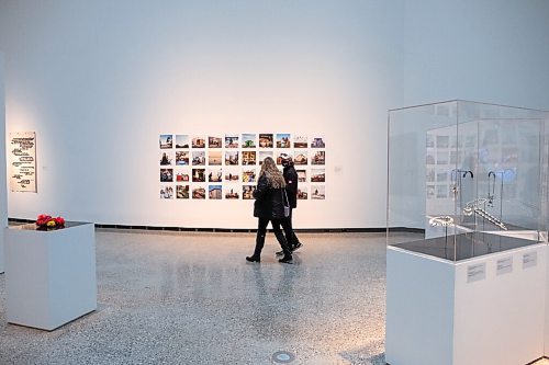 Daniel Crump / Winnipeg Free Press. Krista Stempnick and her husband Kirk Scott walk past a collection of photos by Brian Adams at Qaumajuq, the newly opened Inuit art centre, at the Winnipeg Art Gallery. March 27, 2021.