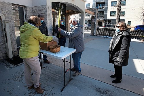 JOHN WOODS / WINNIPEG FREE PRESS
Michelle Garlinski and John MacPhail hand out palms to Harold and Valerie Prysazniuk as people line up for palms and Palm Sunday Mass at Holy Rosary Church in Winnipeg Sunday, March 28, 2021. 

Reporter: ?