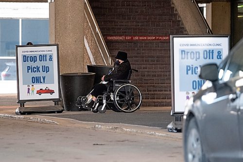 Daniel Crump / Winnipeg Free Press. A person waits to be picked-up outside the RBC Convention Centre downtown after receiving their  COVID-19 vaccination Wednesday afternoon. March 31, 2021.
