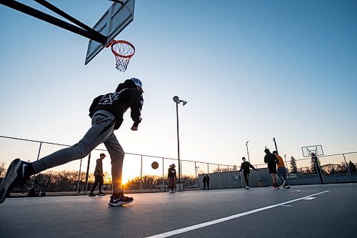 Daniel Crump / Winnipeg Free Press. Benji Munro (front) and friends play basketball at the Corydon Community Centre in Crescentwood on Wednesday evening. March 31, 2021.