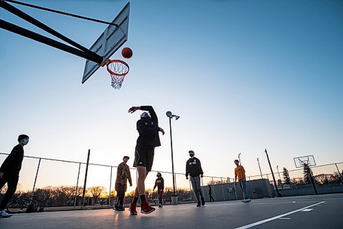 Daniel Crump / Winnipeg Free Press. Asun Ducharme takes a shot as he plays basketball with friends at the Corydon Community Centre in Crescentwood on Wednesday evening. March 31, 2021.