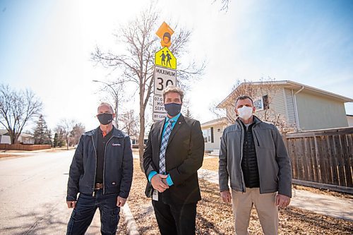 MIKE SUDOMA / WINNIPEG FREE PRESS 
(Left to right) Chuck Lewis, Kevin Klein, and David Stoesz stand in front of the first of many blinking amber traffic lights that will be added to make school zone speed limit signs more visible in highly ticketed areas. 
April 1, 2021