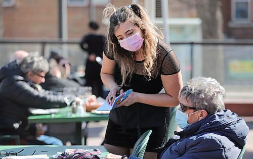 RUTH BONNEVILLE / WINNIPEG FREE PRESS 

Local -  Weather Standup 

Magda Buratchuk, takes food orders from customers on the patio as they take advantage of the sunshine and warming temperatures at Saffrons on Corydon on Thursday.  
 

April 01, 2021