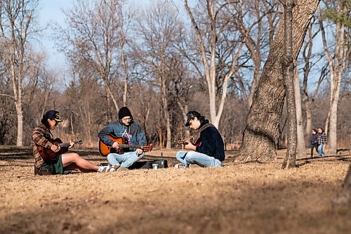 Daniel Crump / Winnipeg Free Press. Bryan Nieva (Pearl Harbour hat), Noah Monney (black toque) and Stephen Adamopoulos (black hat) jam in St. Vital Park Friday evening. The three friends began jamming together as a way to combat pandemic isolation and have titled their band Well Talk Later. April 2, 2021.