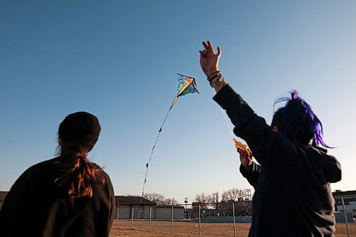 Daniel Crump / Winnipeg Free Press. Sisters Carly Sanderson (left) and Baby Sanderson (right) fly kites on a sunny evening at Sargent Park in Winnipegs West End. April 2, 2021.