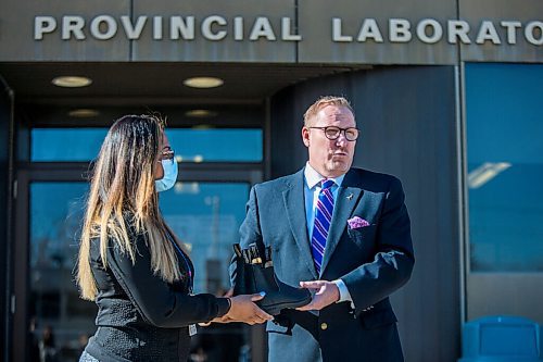 MIKAELA MACKENZIE / WINNIPEG FREE PRESS

Finance minister Scott Fielding hands laboratory technician Chaturika Jayawardanamake a pair of shoes at a budget announcement at Cadham Provincial Laboratory in Winnipeg on Tuesday, April 6, 2021. For Carol Sanders story.

Winnipeg Free Press 2021