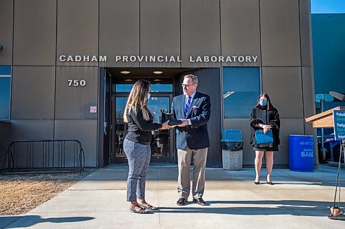 MIKAELA MACKENZIE / WINNIPEG FREE PRESS

Finance minister Scott Fielding hands laboratory technician Chaturika Jayawardanamake a pair of shoes at a budget announcement at Cadham Provincial Laboratory in Winnipeg on Tuesday, April 6, 2021. For Carol Sanders story.

Winnipeg Free Press 2021