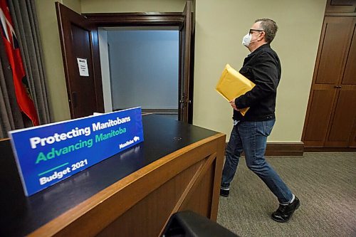 MIKE DEAL / WINNIPEG FREE PRESS
Columnist Dan Lett picks up his physical copy of the embargoed 2021 Budget at the Manitoba Legislative building Wednesday morning. 
210407 - Wednesday, April 07, 2021.