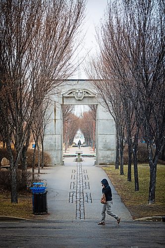 MIKE DEAL / WINNIPEG FREE PRESS
A person walks past the Alloway Arch close to Union Station at The Forks as a light rain falls Thursday afternoon.
The Alloway Arch is made from a part of the façade of the original Alloway and Champion Bank, which once stood at 362 Main Street.
210408 - Thursday, April 08, 2021.