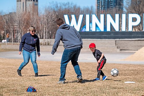 Daniel Crump / Winnipeg Free Press. (L to R) Elicia Dueck-Read, Jodi Dueck-Read and Felix Dueck-Read play soccer in a field at the Forks on Saturday morning. April 10, 2021.