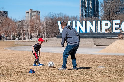 Daniel Crump / Winnipeg Free Press. (L to R) Felix Dueck-Read and Jodi Dueck-Read play soccer in a field at the Forks on Saturday morning. April 10, 2021.