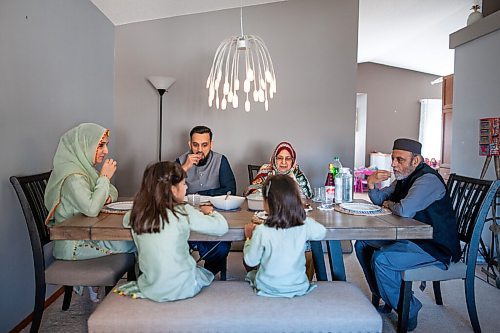 Daniel Crump / Winnipeg Free Press. Waleeds family, including grandparents who also live in the home, sit around a table as they demonstrate breaking the ramadan fast. April 10, 2021.