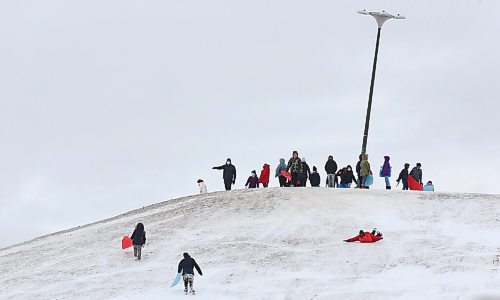 MIKE DEAL / WINNIPEG FREE PRESS
School kids take turns to slid down the hill on Civic Park in East Kildonan Wednesday morning. 
210414 - Wednesday, April 14, 2021.