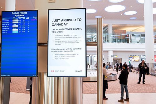 MIKE SUDOMA / WINNIPEG FREE PRESS  
Electronic signage indicating quarantine/isolation practices for travellers entering Manitoba hang on a pillar as travellers grab their luggage at Winnipeg James Armstong Richardson International Airport Friday afternoon.
April 16, 2021